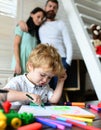 Happy family of three drawing together. Cheerful parents playing with son draw together at a home. Father mother and Royalty Free Stock Photo