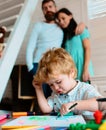 Happy family of three drawing together. Cheerful parents playing with son draw together at a home. Father mother and Royalty Free Stock Photo