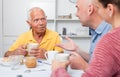 Happy family of three drinking tea in the kitchen