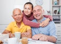 Happy family of three drinking tea in the kitchen