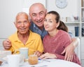 Happy family of three drinking tea in the kitchen