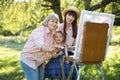 Happy family three generations of women. Family painting outdoors. Cute little girl having fun with her mom and grandma Royalty Free Stock Photo