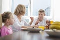 Happy family of three having breakfast at table Royalty Free Stock Photo