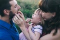 Happy family of three having fun and fooling around in the field. Dad, mom and daughter are playing and having fun in a flower Royalty Free Stock Photo