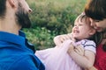 Happy family of three having fun and fooling around in the field. Dad, mom and daughter are playing and having fun in a flower Royalty Free Stock Photo