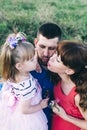 Happy family of three having fun and fooling around in the field. Dad, mom and daughter are playing and having fun in a flower Royalty Free Stock Photo