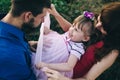 Happy family of three having fun and fooling around in the field. Dad, mom and daughter are playing and having fun in a flower Royalty Free Stock Photo