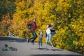 Happy family of three jumping on rural road in solar autumn day Royalty Free Stock Photo