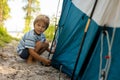 Happy family, kids, boy brothers and a dog,playing around pitched tent on the beach, while wild camping in Norway, summertime Royalty Free Stock Photo