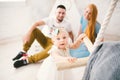 A happy family of three. Mom, dad, child one year old girl in dress play, laugh, smile in bright room. Sunny Royalty Free Stock Photo