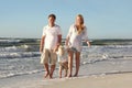Happy Family of Three People Walking on Beach Along Ocean Royalty Free Stock Photo