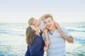 Happy family of three - pregnant mother, father and daughter embracing, laughhing and having fun walking on the beach. Family vaca Royalty Free Stock Photo