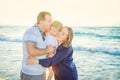 Happy family of three - pregnant mother, father and daughter embracing, laughhing and having fun walking on the beach. Family vaca Royalty Free Stock Photo