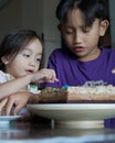 Happy family with two sibling decorating birthday cake at home. Royalty Free Stock Photo