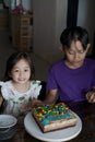 Happy family with two sibling decorating birthday cake at home. Royalty Free Stock Photo