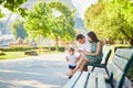 Happy family of three sitting on the bench near the Eiffel tower Royalty Free Stock Photo