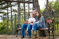 Happy family sitting on a bench in a park enjoying their time together. Royalty Free Stock Photo