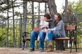 Happy family of three sitting on a bench in a park enjoying their time together. Royalty Free Stock Photo