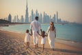 Happy family of three walking on the beach with Dubai city skyline in the background, a family parents with their children walking Royalty Free Stock Photo