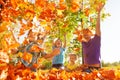 Happy family throwing leaves in air while sitting Royalty Free Stock Photo