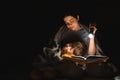 Happy family. Time for stories. Delighted happy cute mother and son enjoying a book before sleeping and using a flashlight Royalty Free Stock Photo