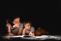 Happy family. Time for stories. Delighted happy cute mother and son enjoying a book before sleeping and using a flashlight Royalty Free Stock Photo