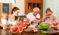 Happy family together with watermelon over dining table Royalty Free Stock Photo