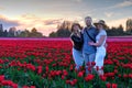 Happy family on tulip fields at sunset.