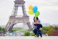 Happy family of two with bunch of colorful balloons in Paris