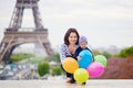 Happy family of two with bunch of colorful balloons in Paris