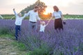 Happy family with two children are having fun outdoors in lavender field in summer. Sunset Royalty Free Stock Photo