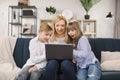 Happy family with two children having good time using laptop. Royalty Free Stock Photo