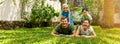 happy family with two children lying in the home backyard garden lawn and looking at camera. banner Royalty Free Stock Photo