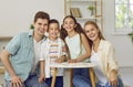 Happy family with two children are playing puzzles at table sitting on floor in living room. Royalty Free Stock Photo