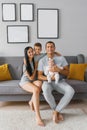 Happy family with two children are sitting on the sofa in their house and smiling Royalty Free Stock Photo