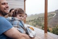 Happy family with two children is sitting on the terrace at home. Young parents covered their kids with checkered blankets Royalty Free Stock Photo
