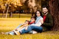 Happy family with two children sitting together on grass Royalty Free Stock Photo