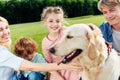 happy family with two children stroking dog Royalty Free Stock Photo
