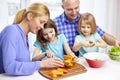 Happy family with two kids cooking at home