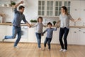 Happy family with two kids dancing in modern kitchen together Royalty Free Stock Photo