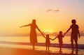 Happy family with two kids having fun at sunset