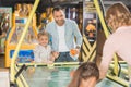 happy family with two kids playing air hockey together in entertainment center Royalty Free Stock Photo