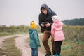 Happy family with two kids playing with drone in the field autumn time