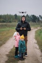 Happy family with two kids playing with drone in the field autumn time