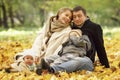 Happy family with two young children in a beautiful autumn park. Love, tenderness and warm relations in the family Royalty Free Stock Photo