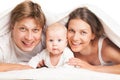 Happy family under blanket on the bed at home Royalty Free Stock Photo