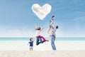 Happy family under heart cloud at beach Royalty Free Stock Photo