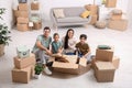 Happy family unpacking moving boxes at their new home Royalty Free Stock Photo