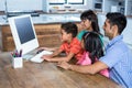 Happy family using computer in kitchen Royalty Free Stock Photo