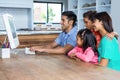 Happy family using computer in the kitchen Royalty Free Stock Photo